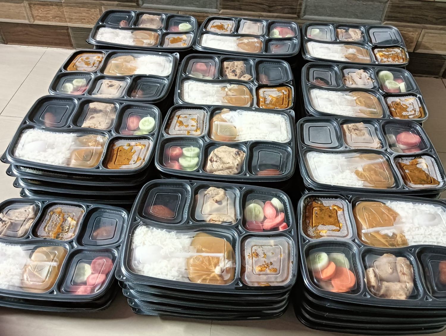 A stack of dozens of packed tiffin trays from Sunita Caterers, ready for delivery